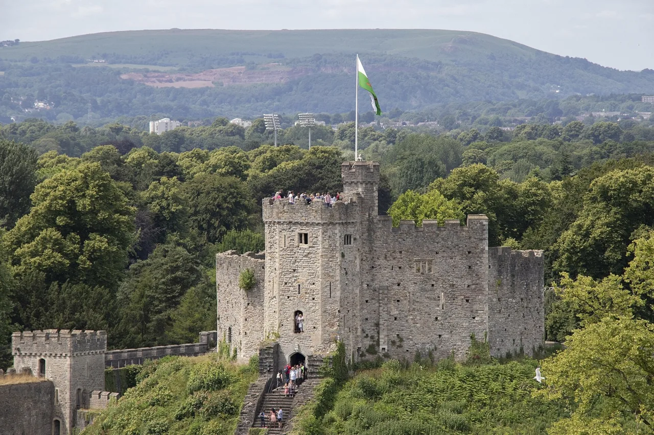 Cardiff Castle’s Norman keep on its grassy mound with wooded hills beyond