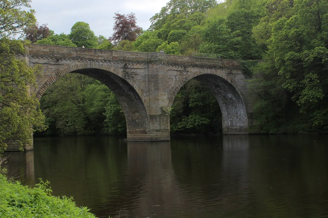 The stone arches of Prebends Bridge reflected in the River Wear