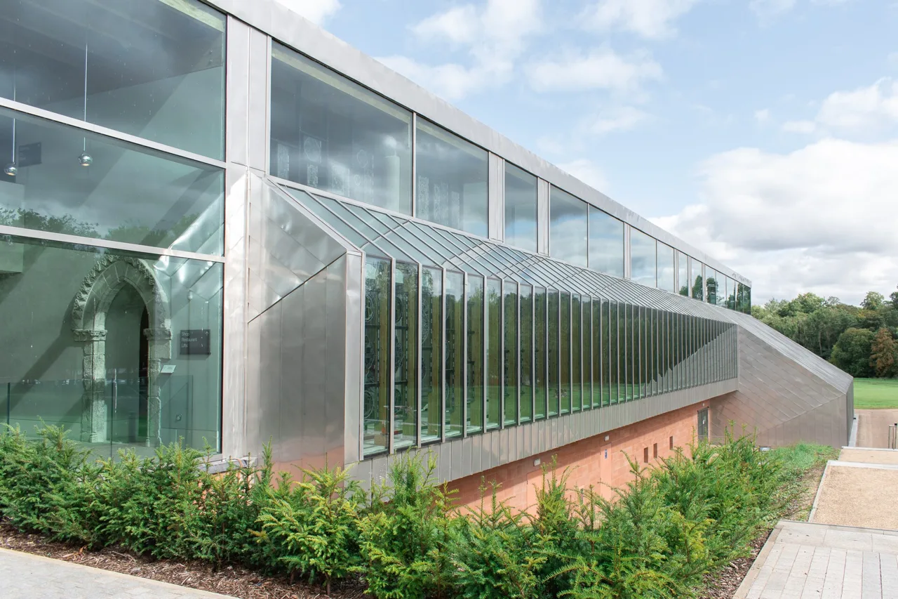 The Burrell Collection’s long glass frontage beside planting and a path
