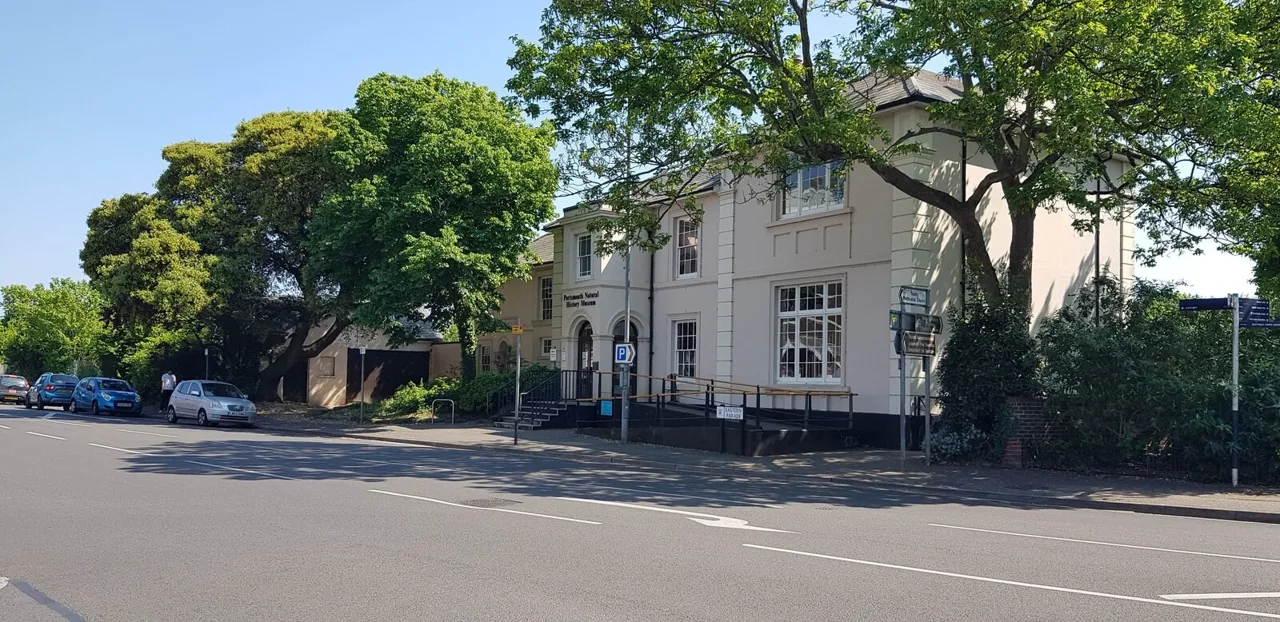 Cumberland House museum beside the road and mature trees in Southsea
