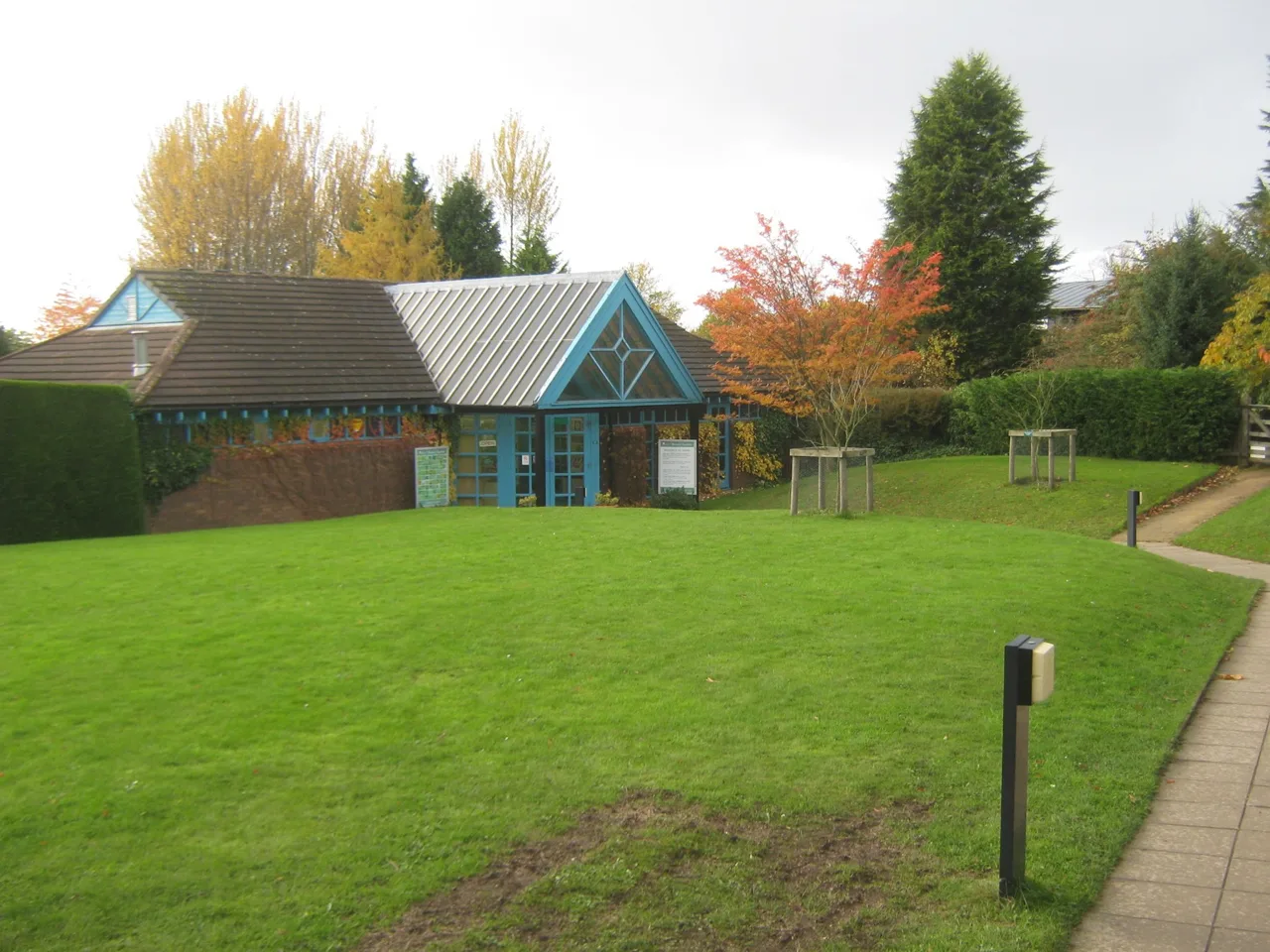 The glazed Botanic Garden Visitor Centre beside lawns and autumn trees