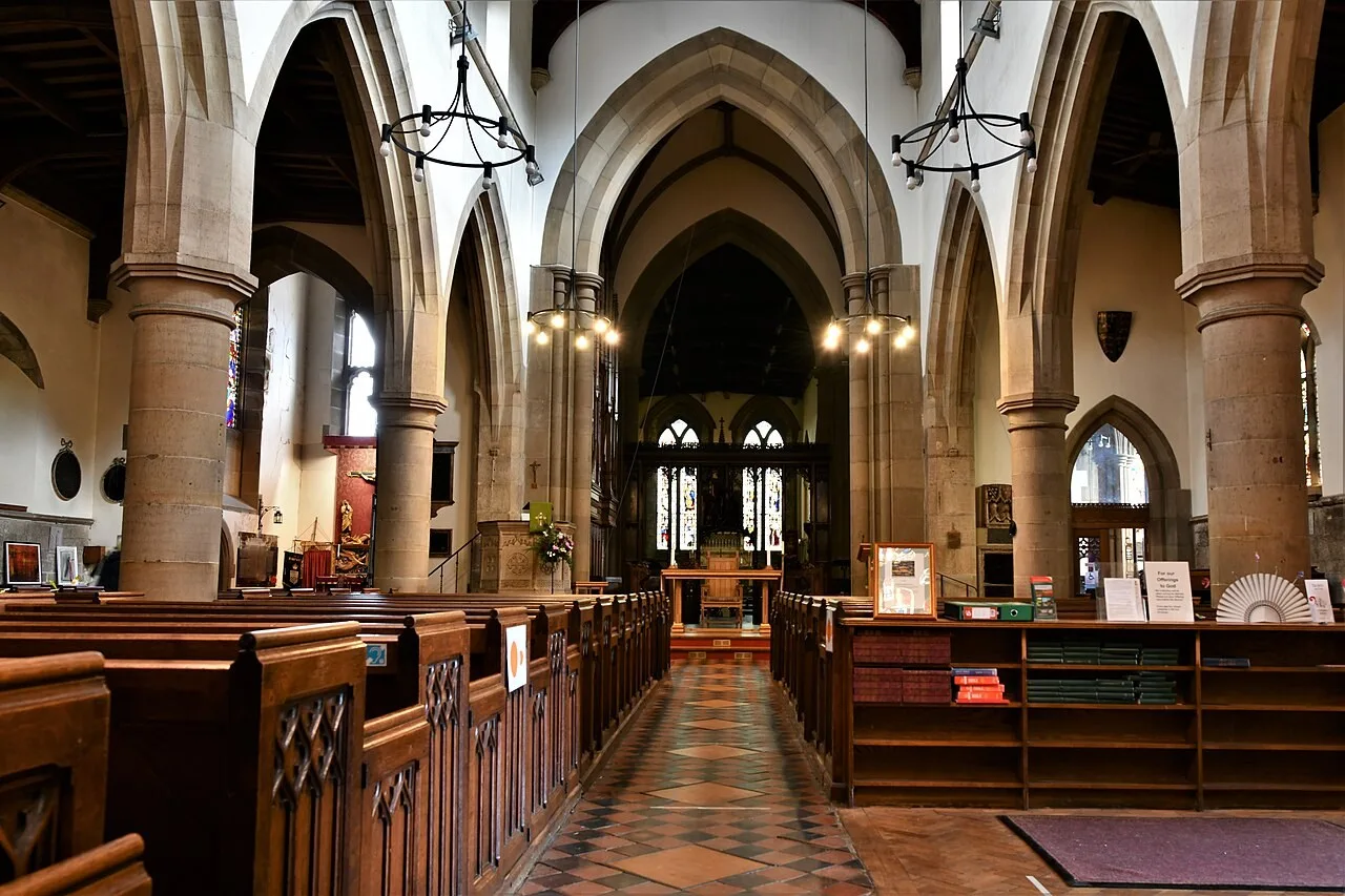 Pews, stone arcades and central aisle inside All Saints’ Church in Bakewell