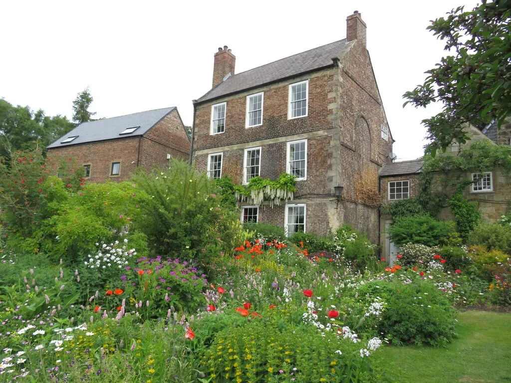 Flower beds beneath the historic buildings at Crook Hall Gardens