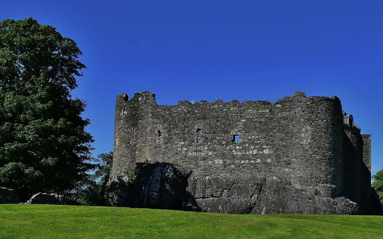 Thick stone walls of Dunstaffnage Castle rising from their rocky base