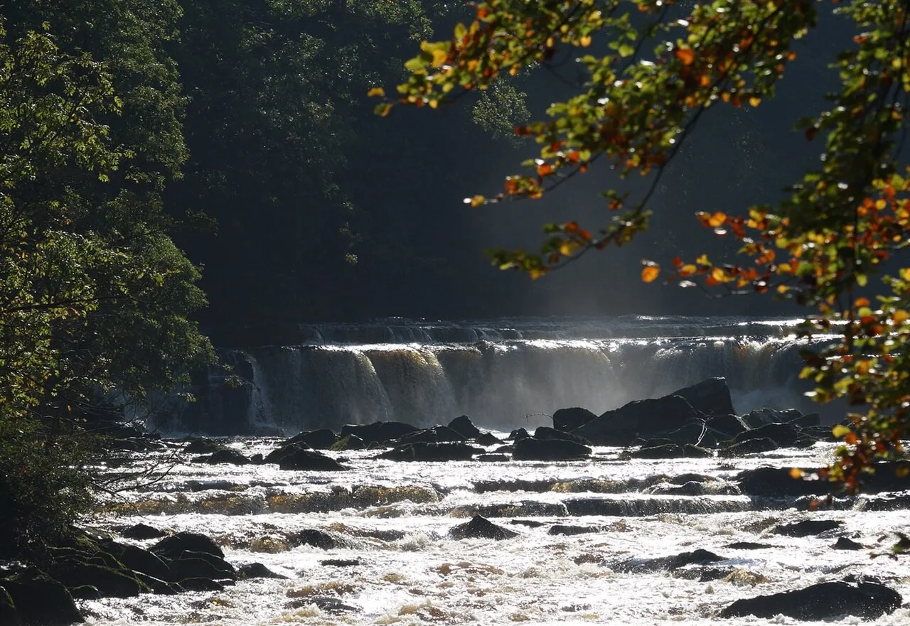 Sunlight on water flowing over the rocky falls of the River Swale in Richmond