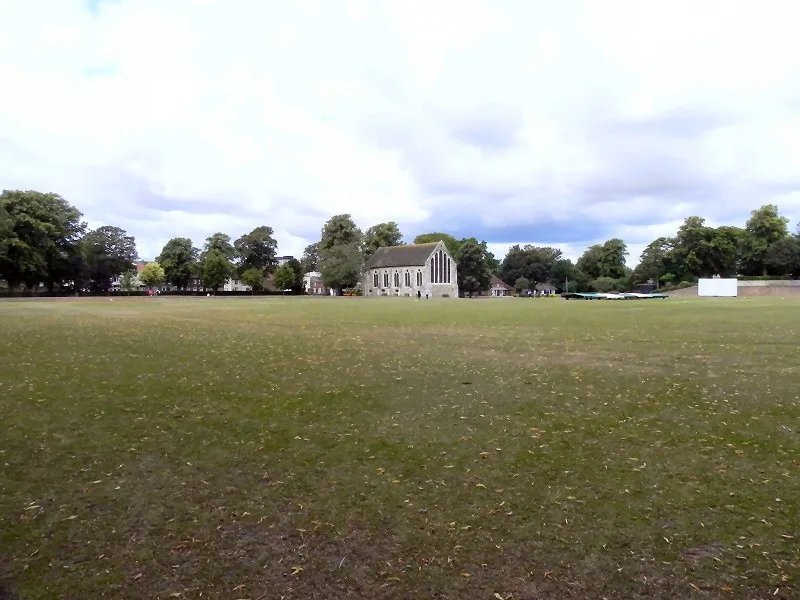 Open grass in Priory Park with the Guildhall beyond