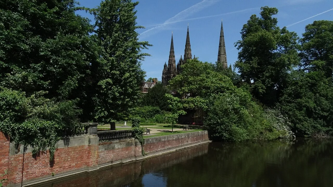 View across Minster Pool towards garden trees and Lichfield Cathedral’s spires