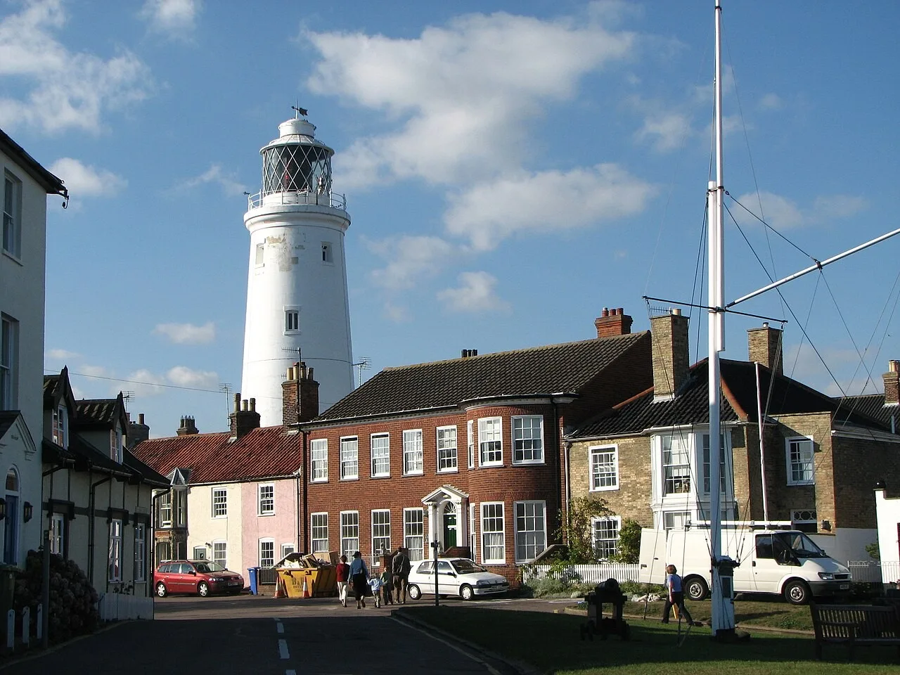 Southwold Lighthouse rises above the houses and pub below