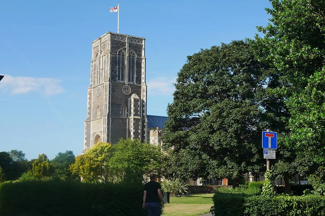 St Edmund’s church tower rises above a garden and trees in Southwold