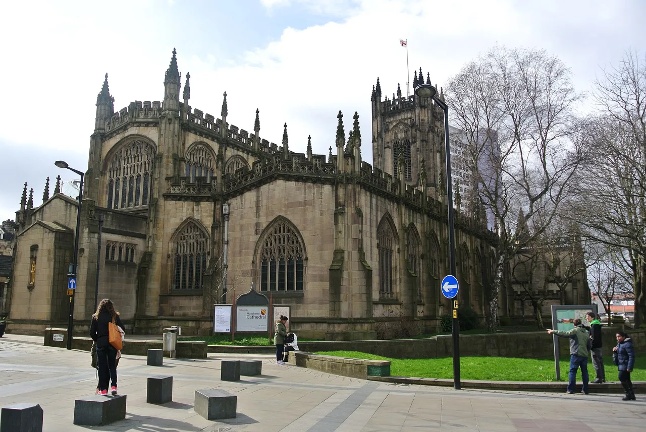 Manchester Cathedral’s stone windows and tower from the surrounding pedestrian area