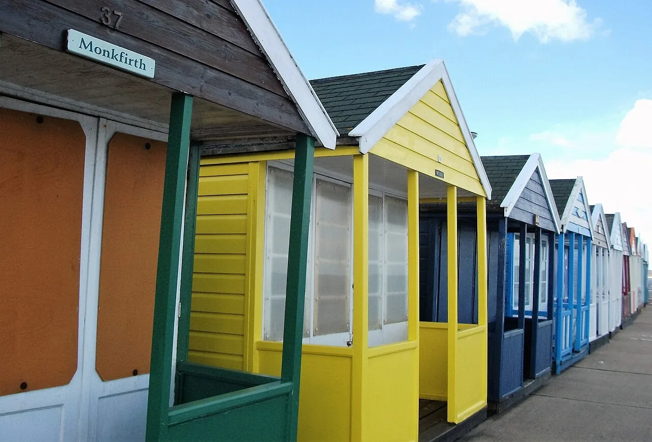 A colourful row of Southwold beach huts beside the promenade
