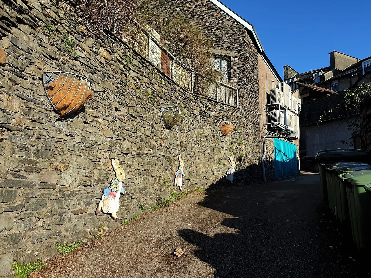Sloping entrance approach beside the stone wall of the World of Beatrix Potter attraction