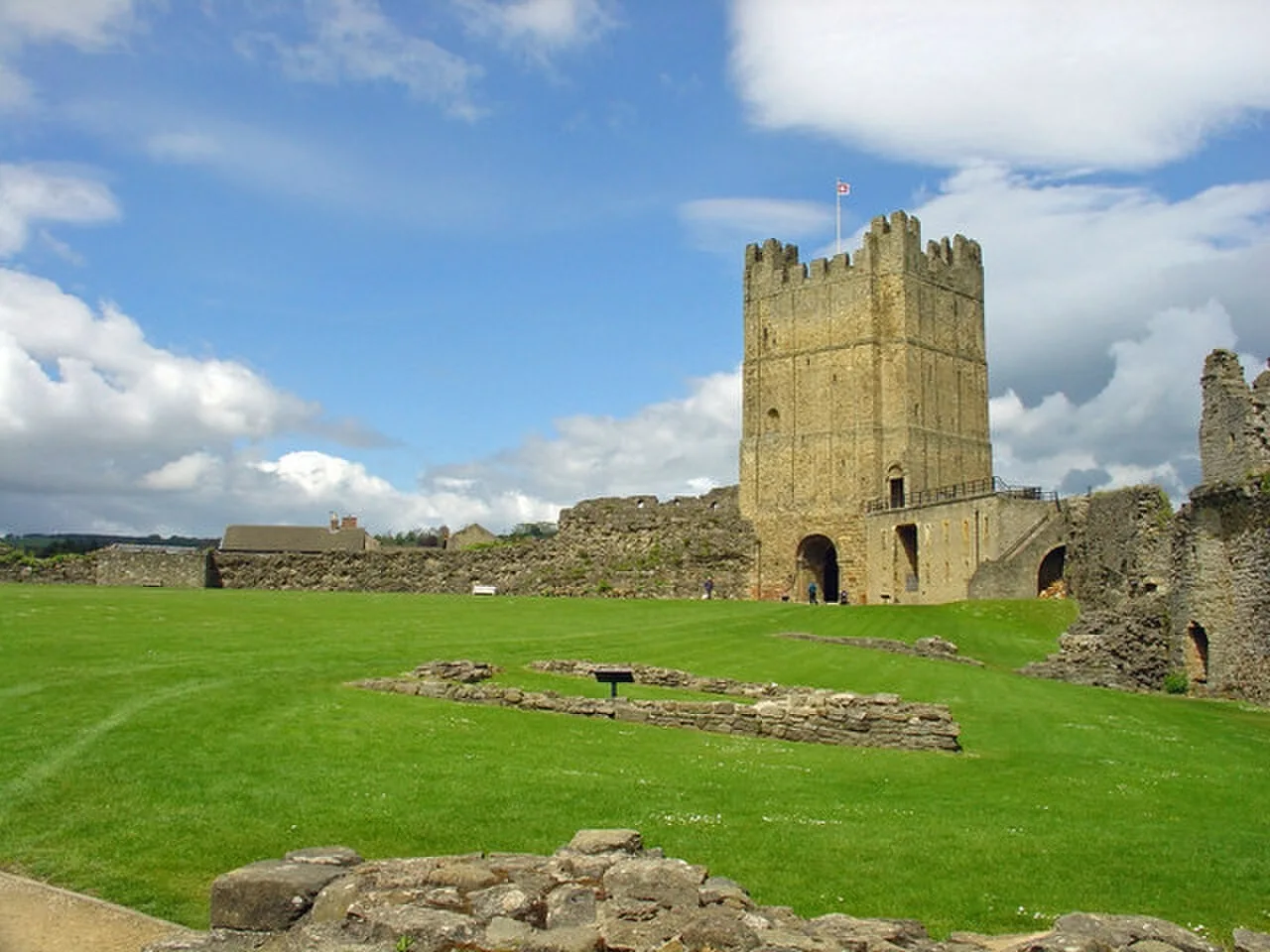 Square stone keep above the grassy bailey at Richmond Castle in North Yorkshire