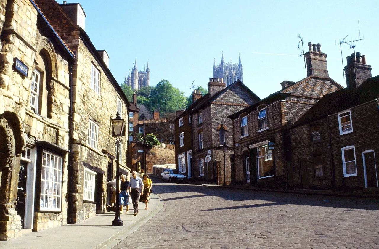 Historic buildings on Lincoln’s Steep Hill with the cathedral towers beyond