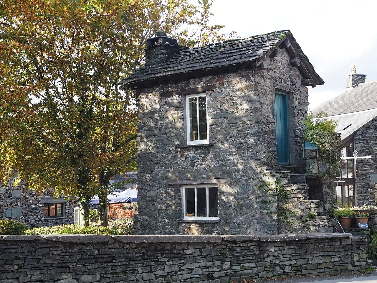 Small stone Bridge House with its windows and slate roof in Ambleside