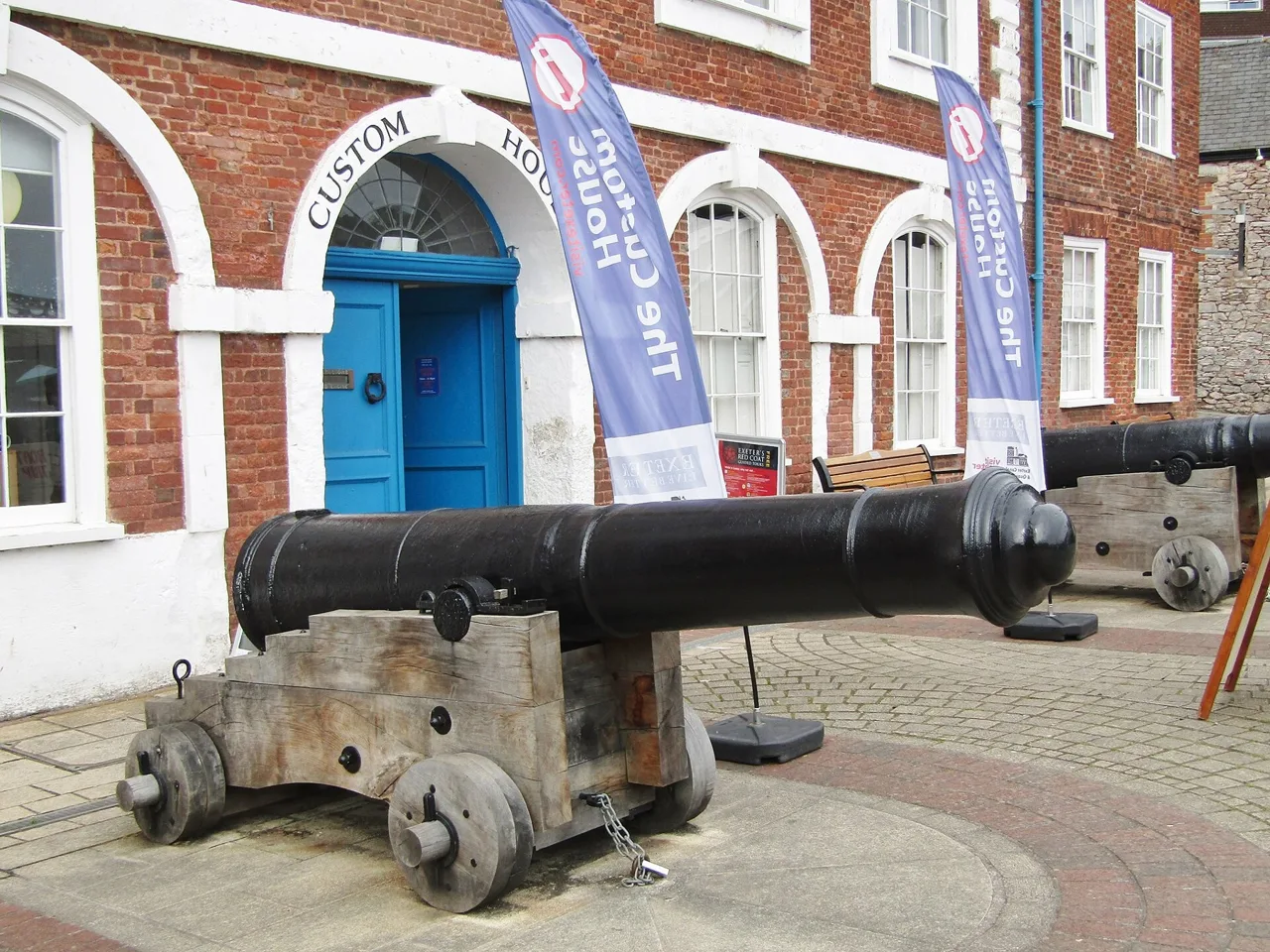 Historic cannons outside the red-brick Exeter Custom House
