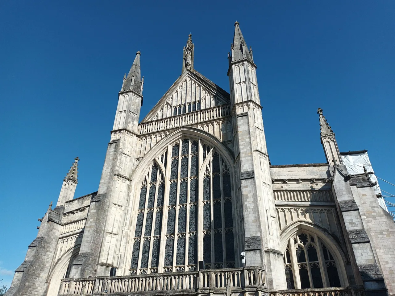 The west front and large window of Winchester Cathedral against a blue sky