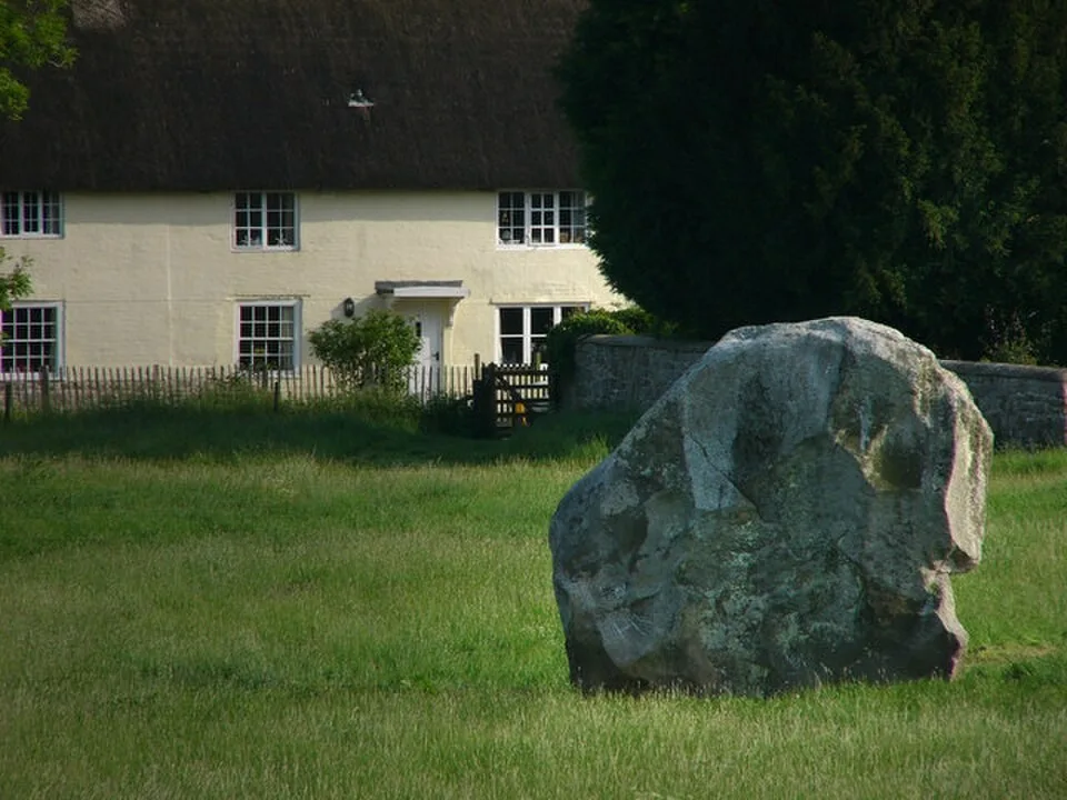 A standing stone at Avebury beside village buildings