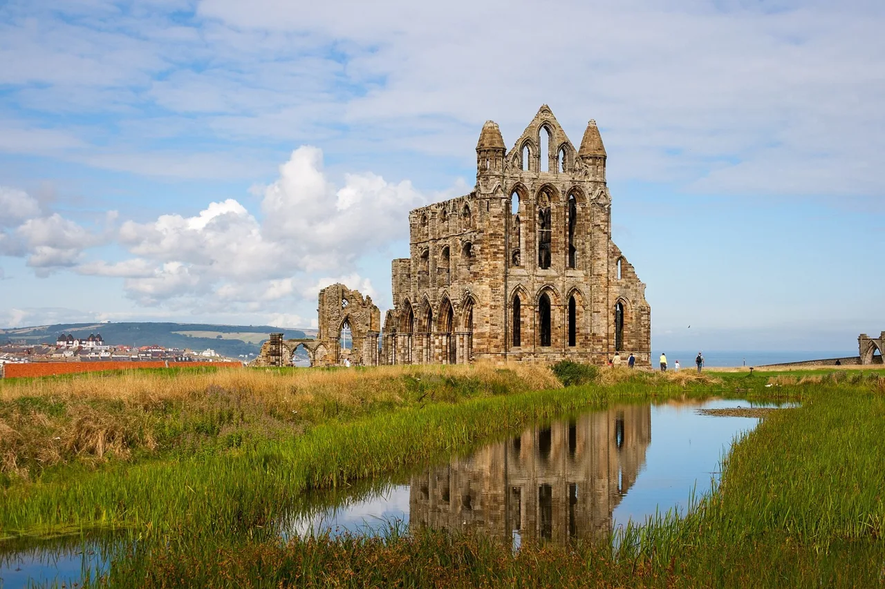 Whitby Abbey’s Gothic ruins reflected in a pond on the headland