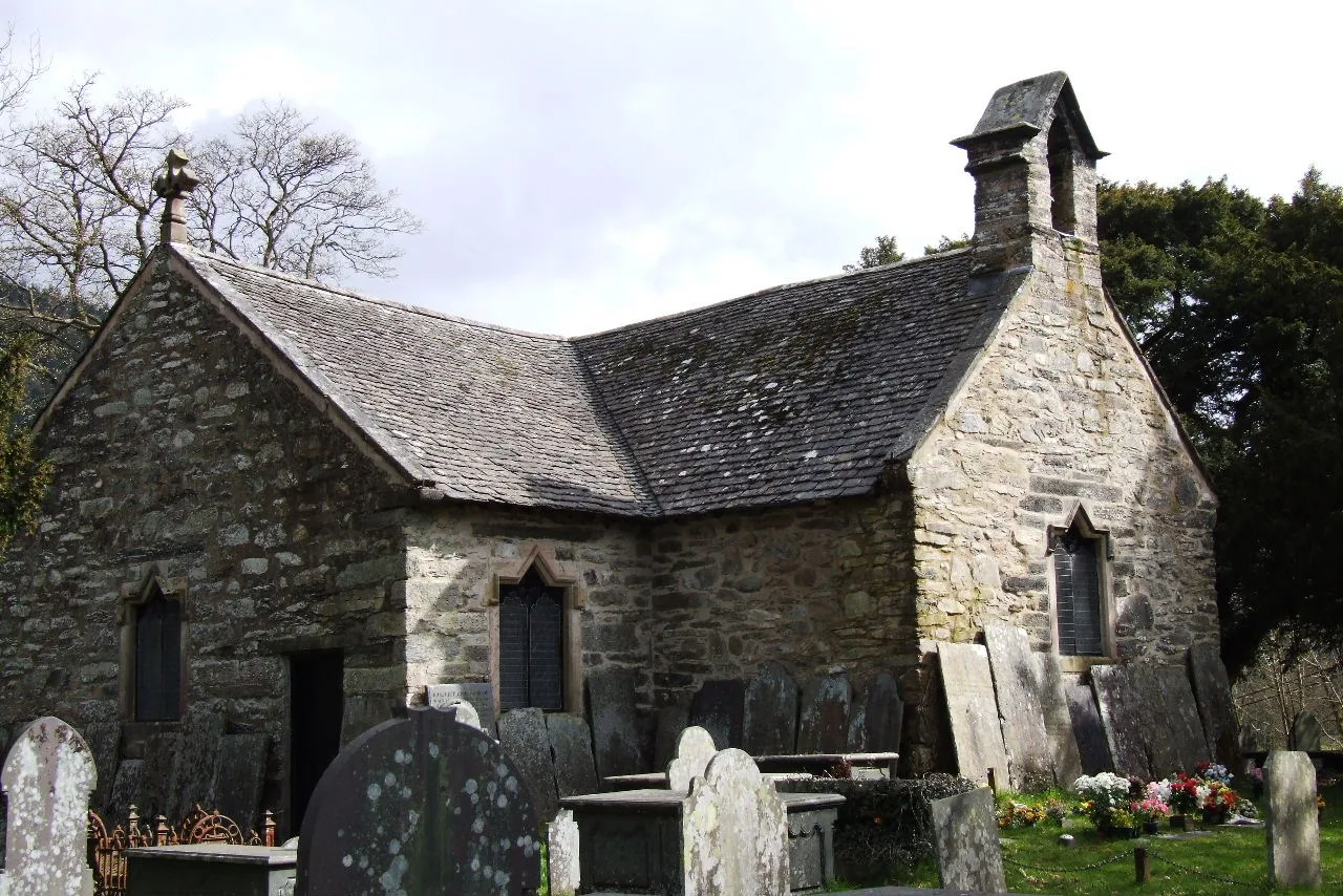 Stone walls and slate roof of St Michael’s Old Church beside its churchyard