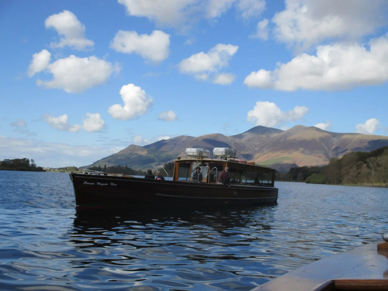 A passenger launch on Derwentwater with fells behind it