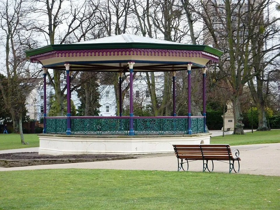 The ornate bandstand beside lawns and benches in Montpellier Gardens