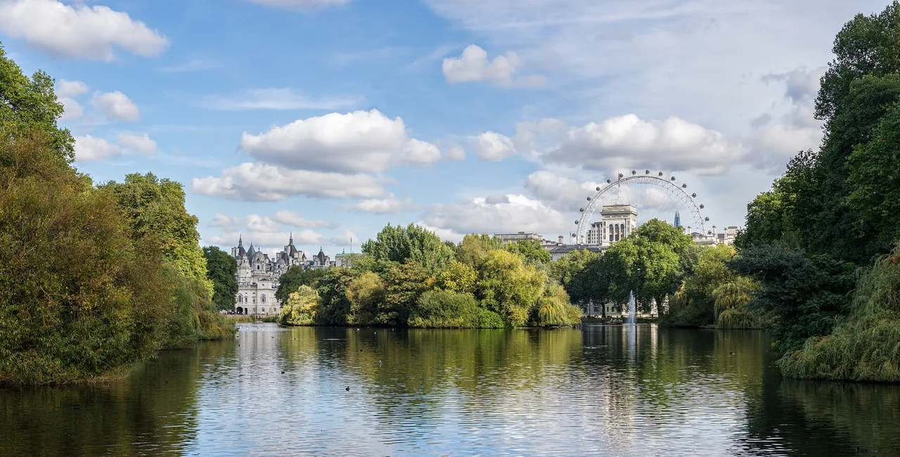 The lake in St James’s Park with trees and London landmarks beyond