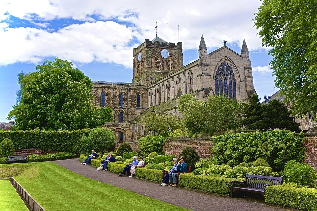 Hexham Abbey above lawns and benches in the Abbey Grounds