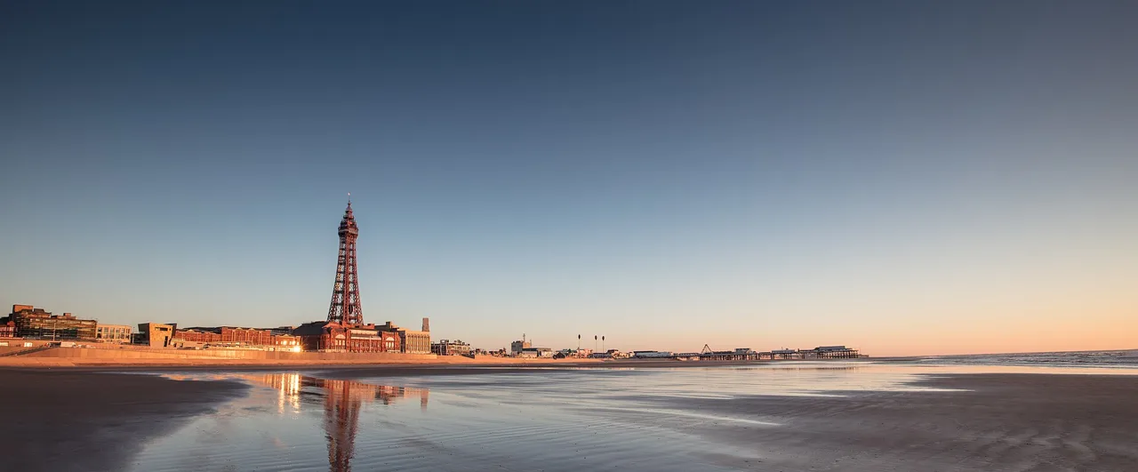 Blackpool Tower and the seafront reflected in the wet sand