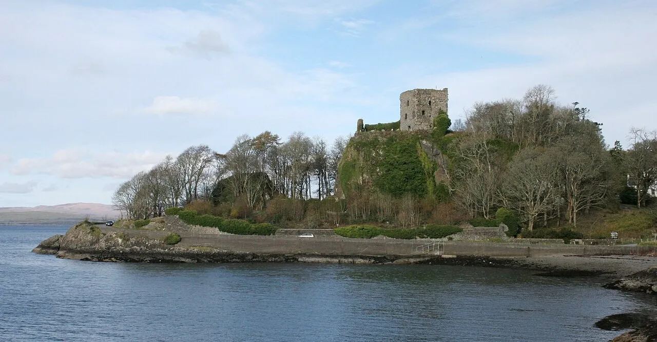 Dunollie Castle ruin above its rocky wooded shore beside Oban Bay