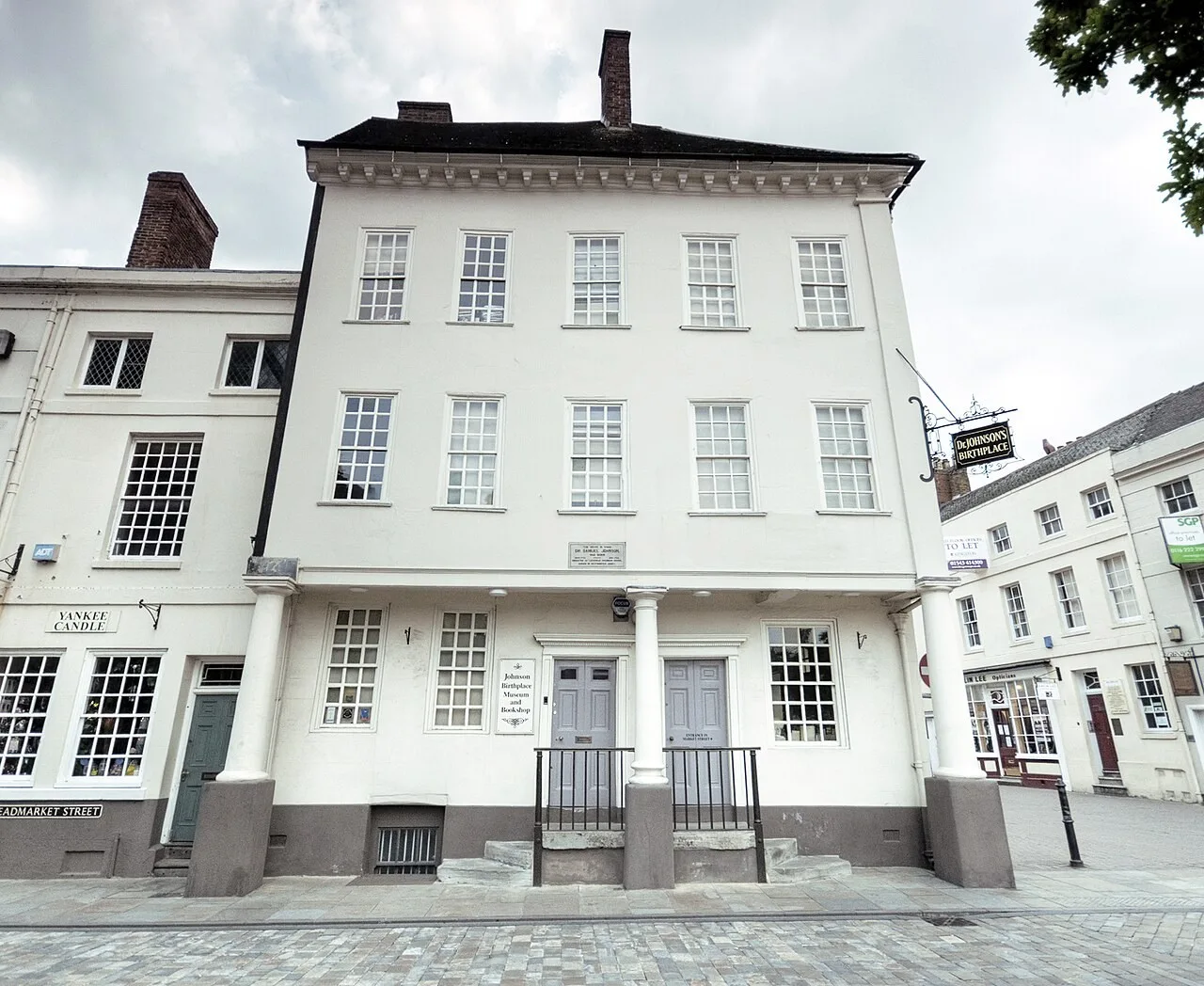 White frontage and columned entrance of Samuel Johnson’s birthplace beside Lichfield Market Square