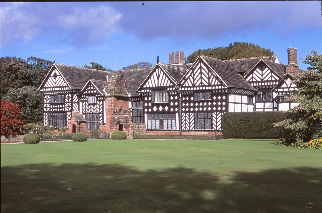 The black-and-white timbered frontage of Speke Hall beside its lawn