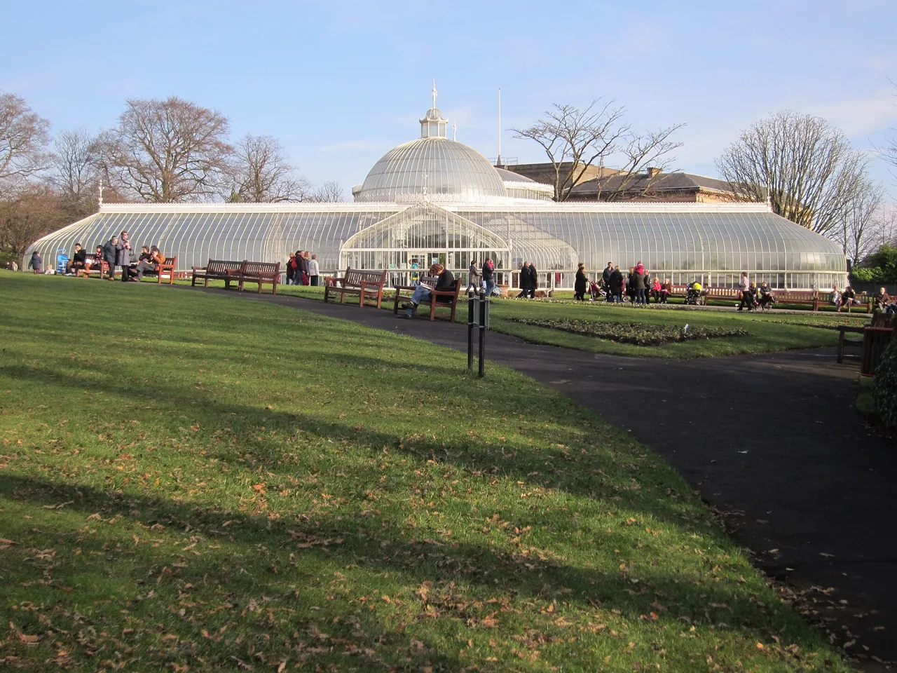 Kibble Palace’s white glasshouse beyond lawns at Glasgow Botanic Gardens
