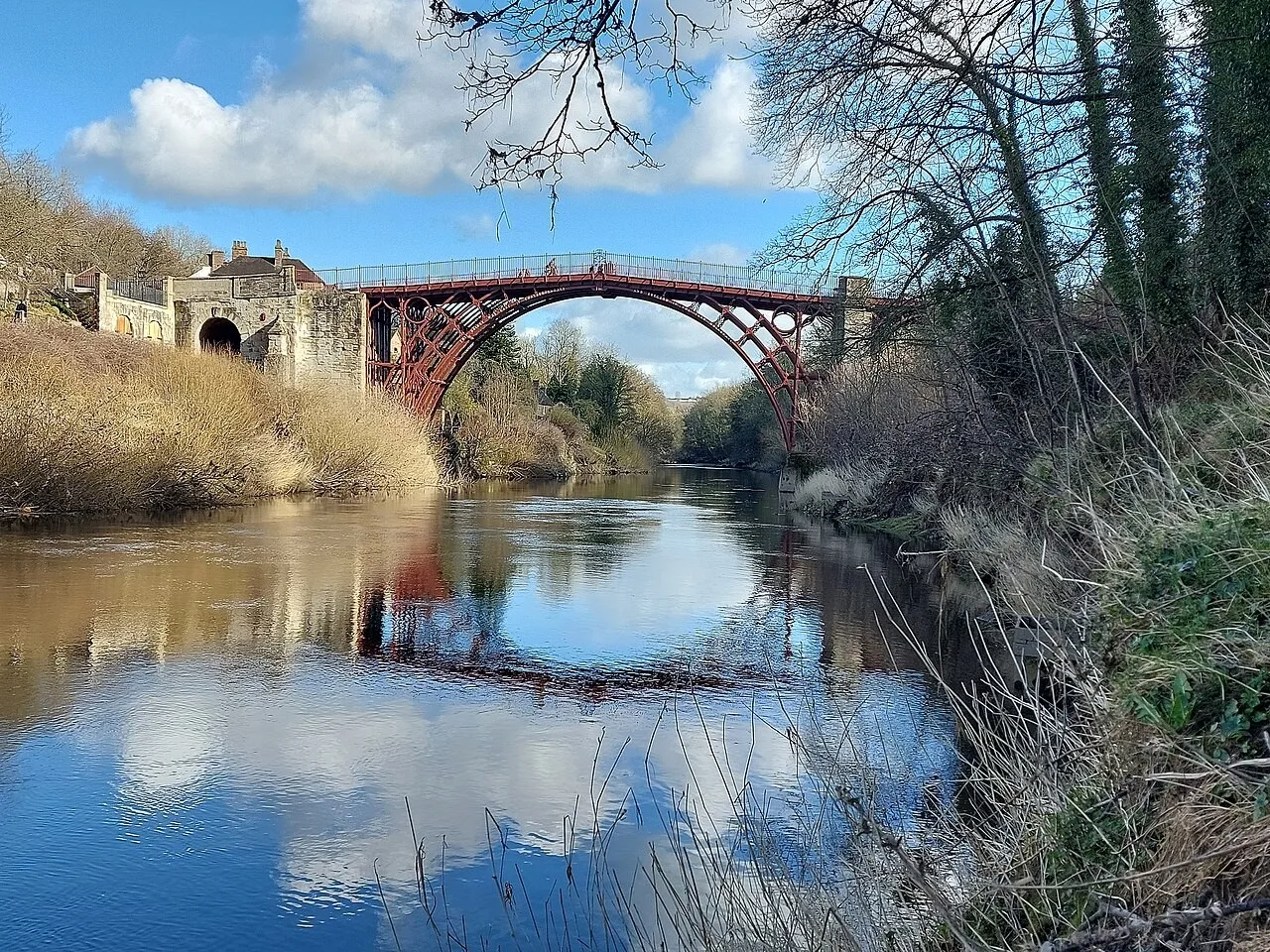 The Iron Bridge arch spans the River Severn between wooded banks