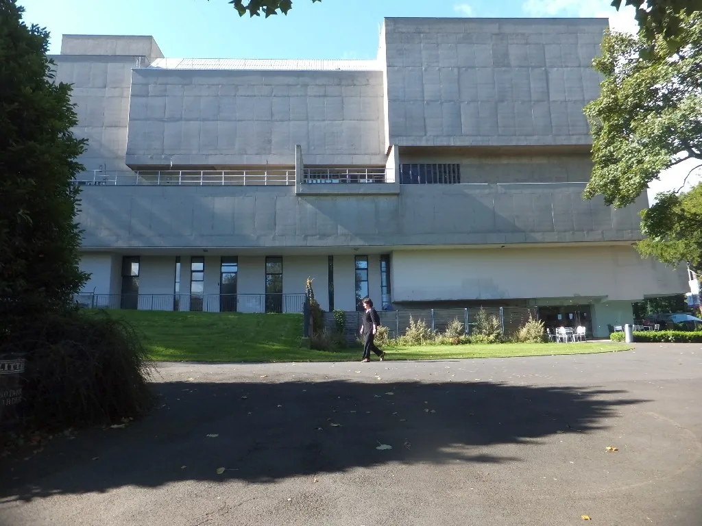 The concrete west facade of Ulster Museum beside a garden path