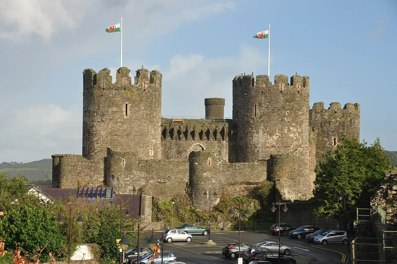 Stone towers and curtain walls of Conwy Castle above the street