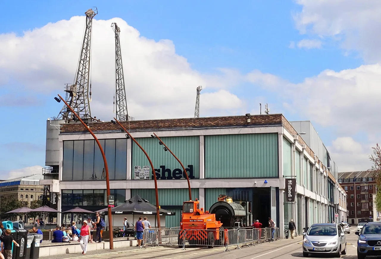 M Shed museum with historic cranes and dockside vehicles outside