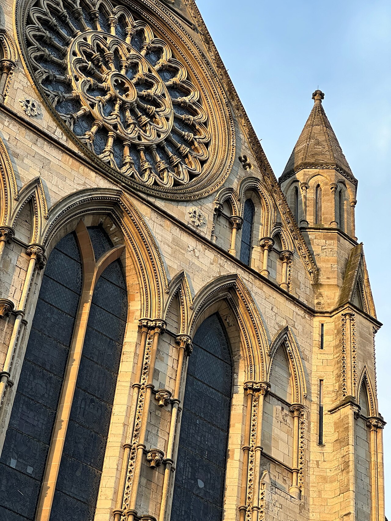 Sunlit carved stone and rose window on York Minster
